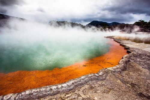 Şampanya Gölü Waiotapu Yeni Zelanda Bu gölden sürekli karbondioksit kabarcıkları yükselir 900 yıl önce oluşan bu kaplıcanın yüzeyindeki sıcaklık 74 dereceye ulaşır Silika bakımından zengin olan gölün kenarları turuncu bir renk almıştır ve arsenik ve antimon sülfür içermektedir
